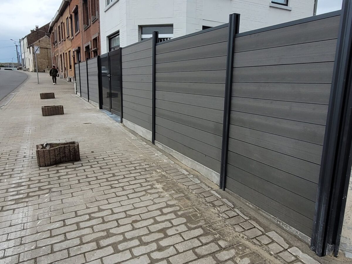 Palissade en lames béton en limite de parcelle le long d'une voirie pavée