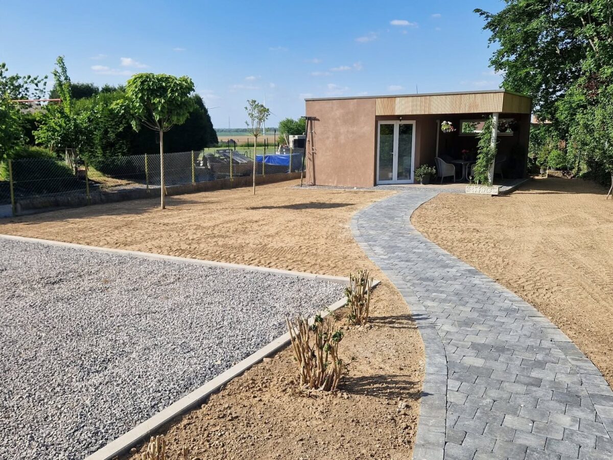 Cheminement pavé en courbe et pelouse en création dans un jardin en fin de chantier