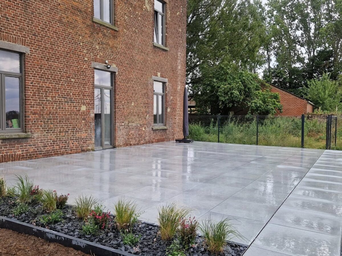 Terrasse en dalles céramiques claires avec caniveau à fente en rive et bande plantée