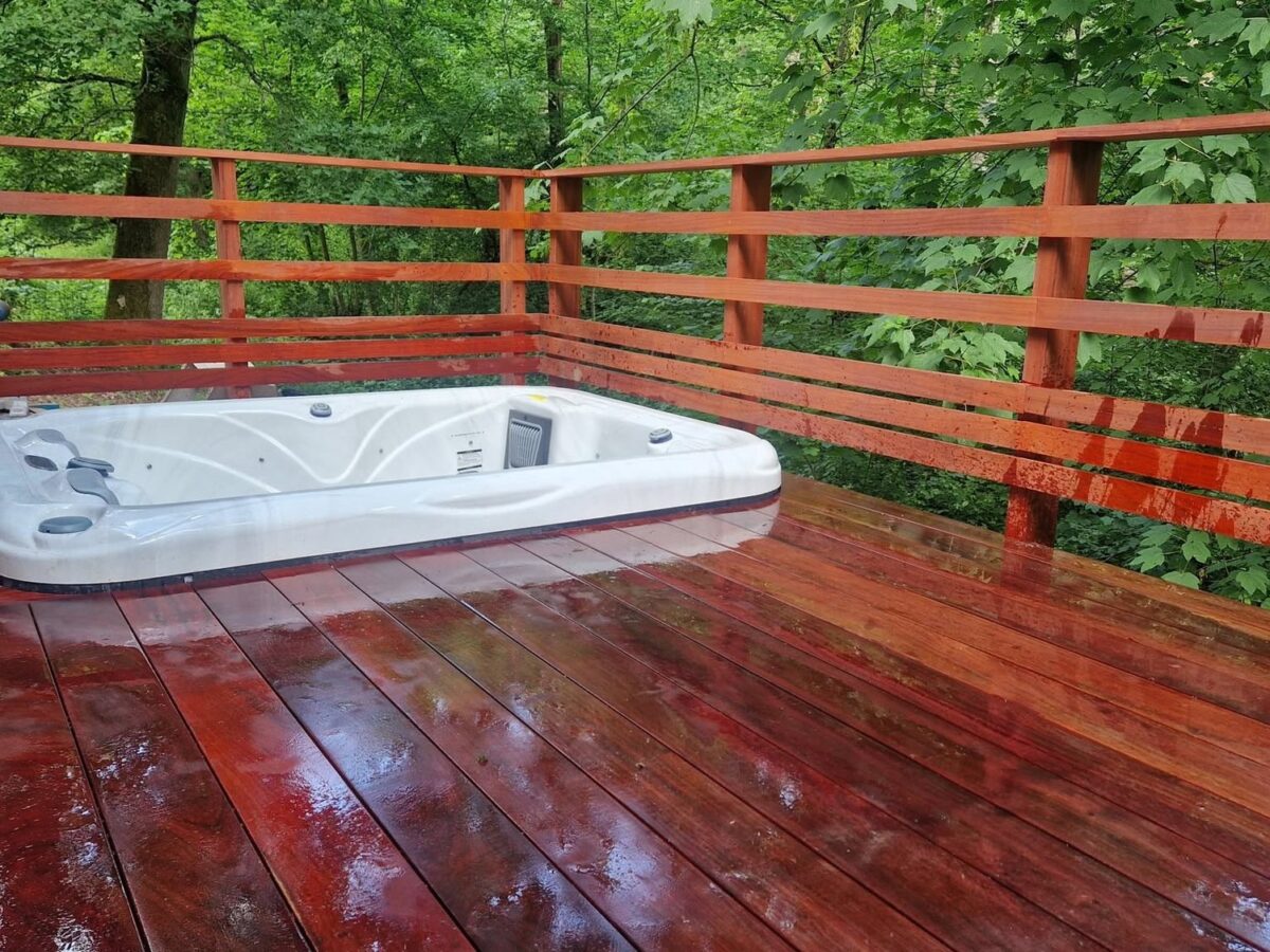 Spa encastré sur un platelage en padouk avec garde-corps à barreaudage horizontal
